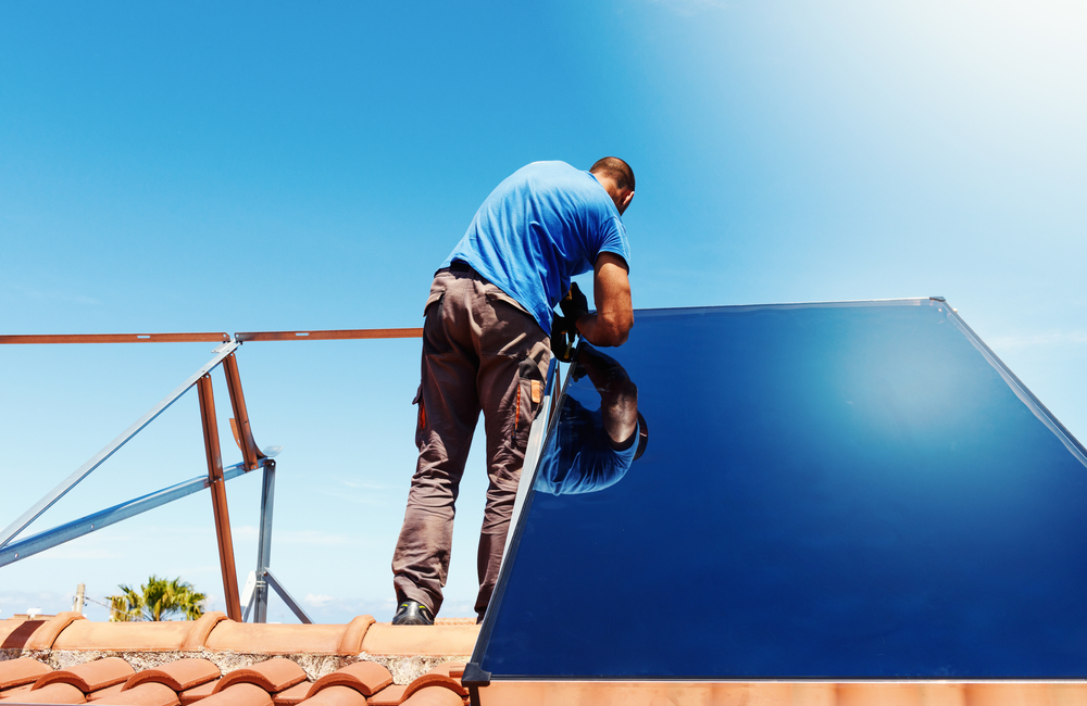 expert en train d'installer des panneaux solaires sur un toit