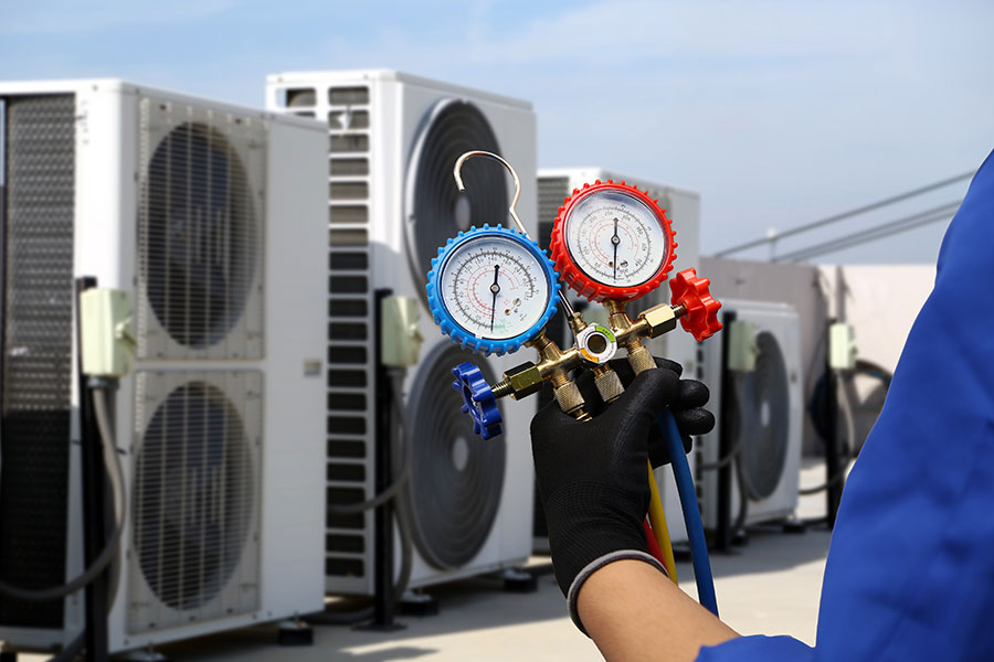 Service de technicien en électricité de climatisation utilisant une jauge de collecteur de mesure pour vérifier l'état du système CVC et le remplissage de réfrigérant du climatiseur après le nettoyage et l'entretien des unités de compresseur.